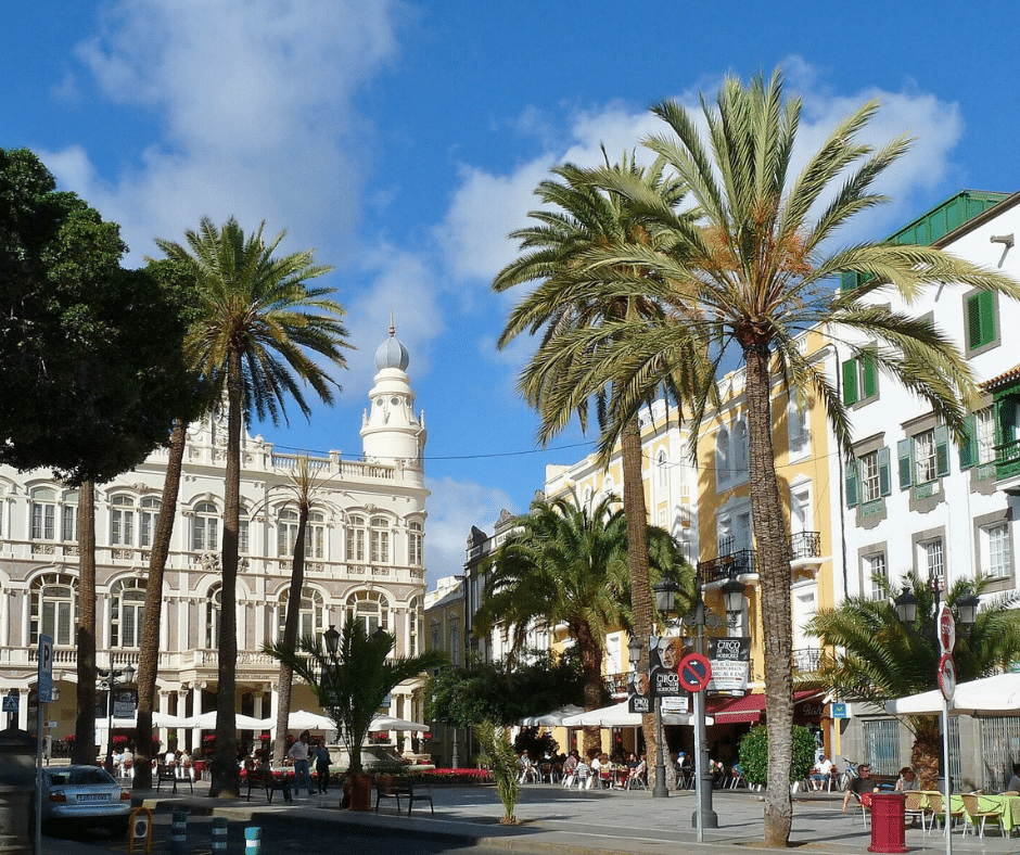 Vegueta old town cobbled street with stone façades and wooden balconies, Santa Ana Cathedral towers in the background, Las Palmas de Gran Canaria.