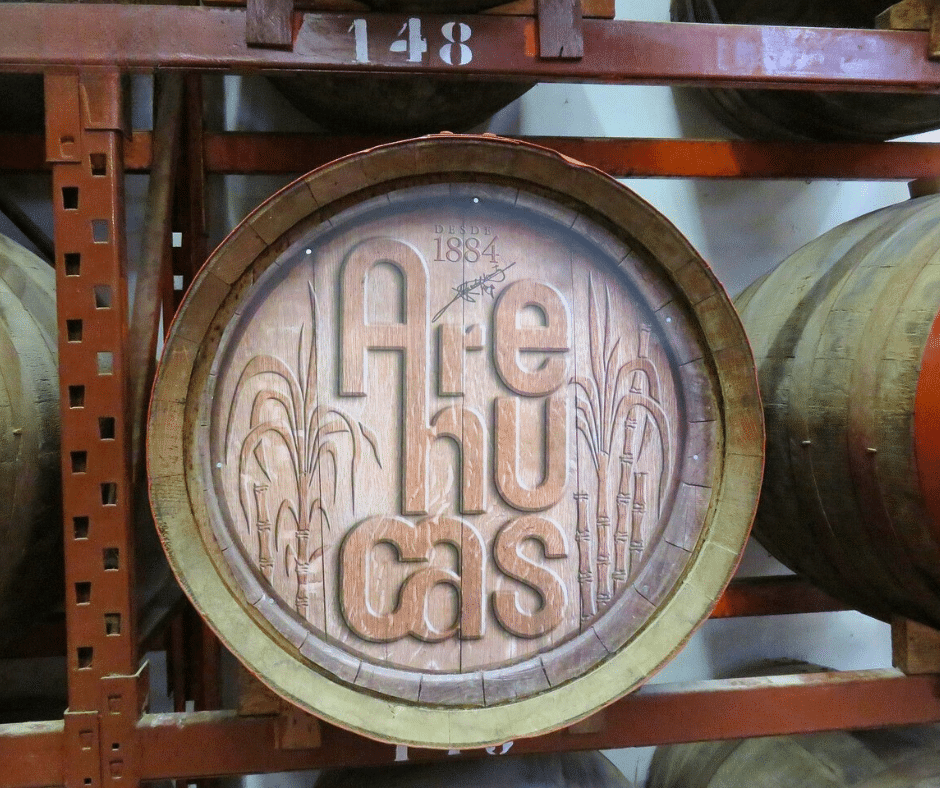 Arehucas Rum Distillery barrel hall in Arucas, rows of oak casks stacked floor to ceiling with a visitor tour walkway, Gran Canaria.